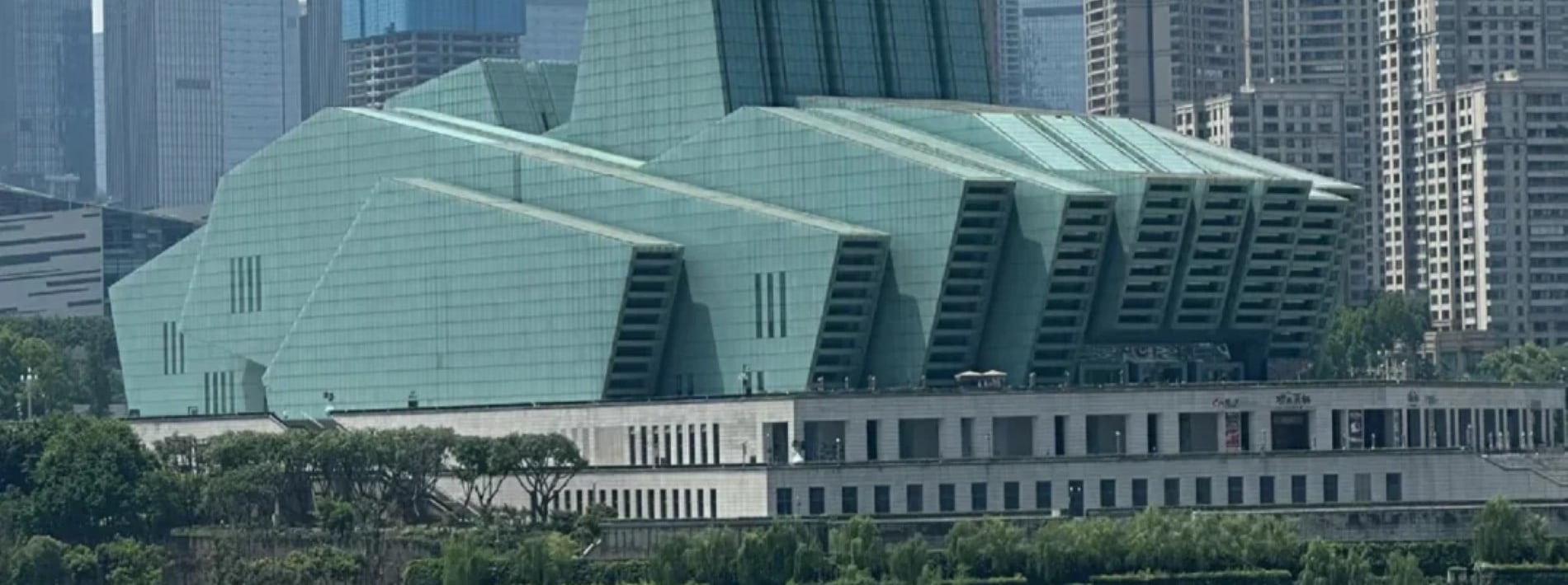 長江的渾黃與嘉陵江的碧綠在此碰撞，界限分明又緩緩相融，連岸邊的重慶大劇院都成了這幕奇景的背景板