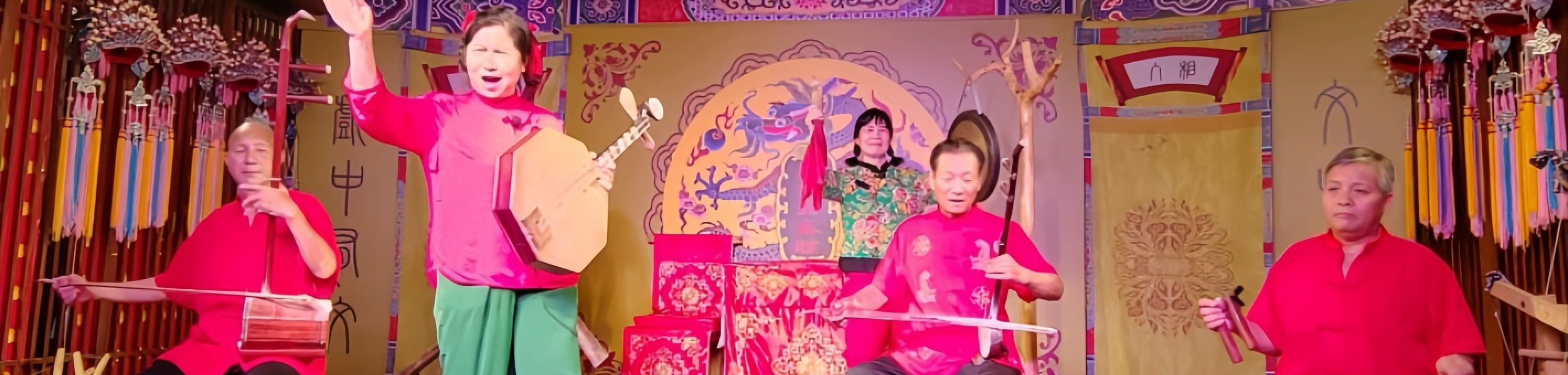 多位表演者呈現陝西民間戲曲的演奏場景,演員們身著統一紅色服飾,有的彈奏傳統樂器,有的引吭高歌 多位表演者呈現陝西民間戲曲的演奏場景,演員們身著統一紅色服飾,有的彈奏傳統樂器,有的引吭高歌