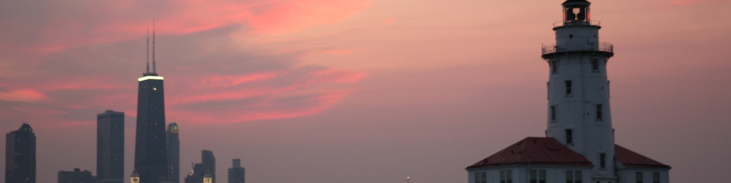 Admire Chicago Harbor Lighthouse glowing beautifully against the colorful evening sunset skies