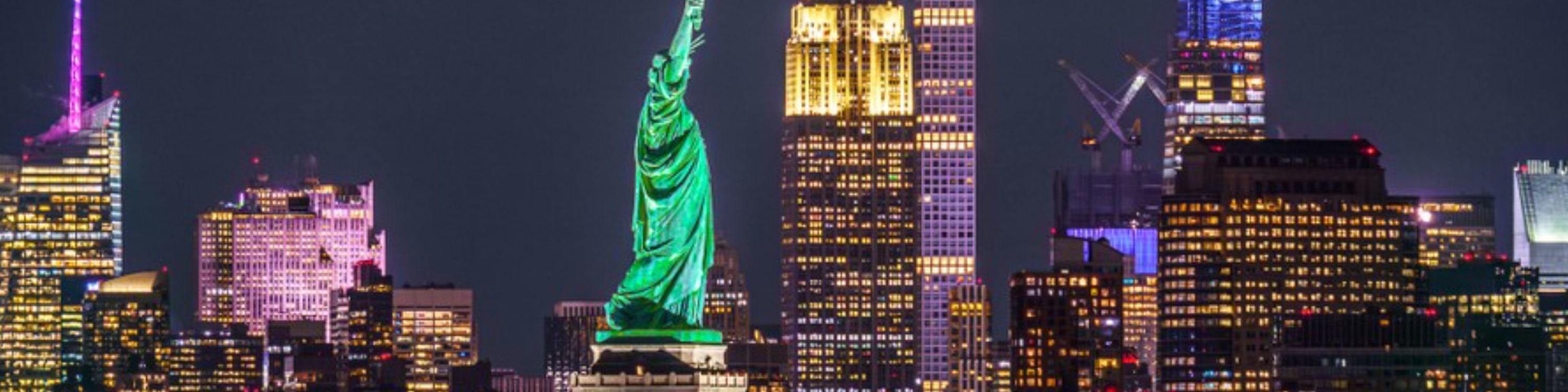 Majestic nighttime view of the Statue of Liberty glowing proudly in New York Harbor