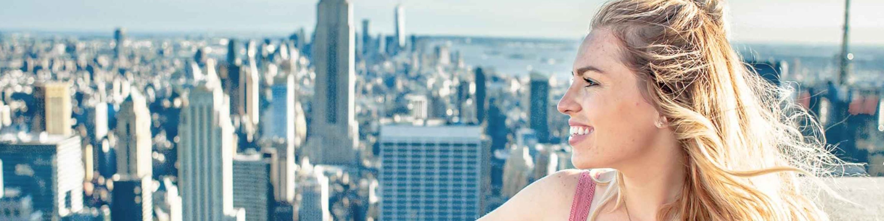 Woman admires New York skyline from Top of the Rock with Empire State Building view