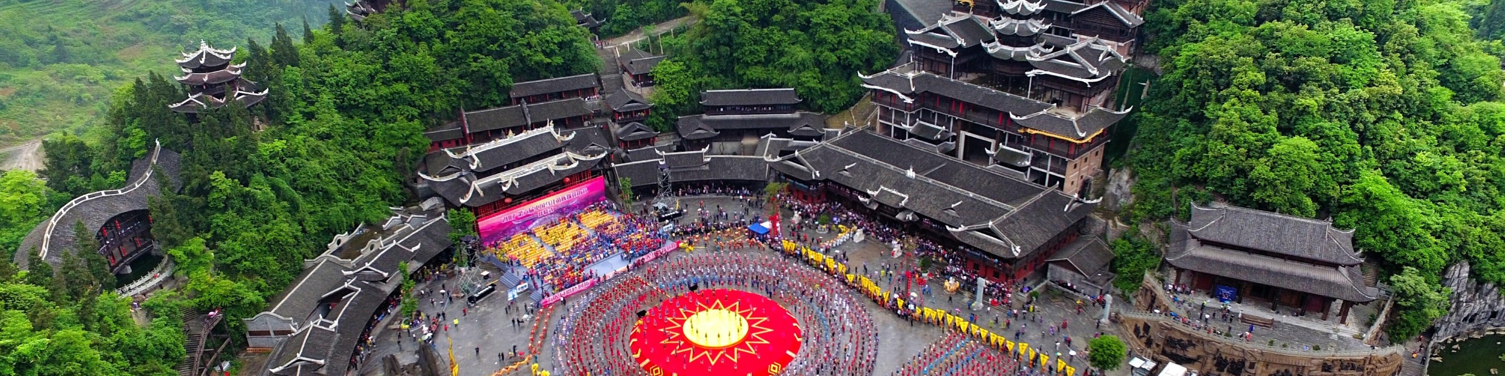 蚩尤九黎城日間全景，九層苗族吊腳塔樓依山而建，飛簷層疊，氣勢雄渾古樸。