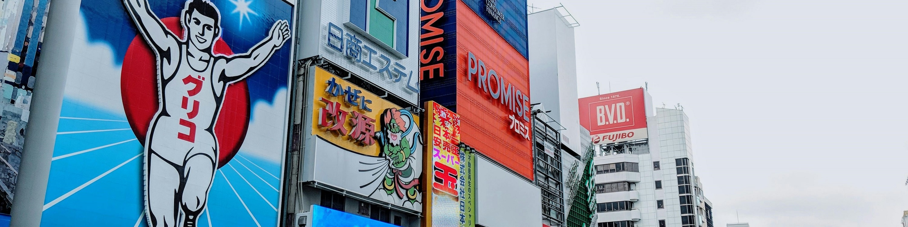 Snap iconic photos at Dotonbori’s famous landmarks, including the Glico running man and bustling canal views.