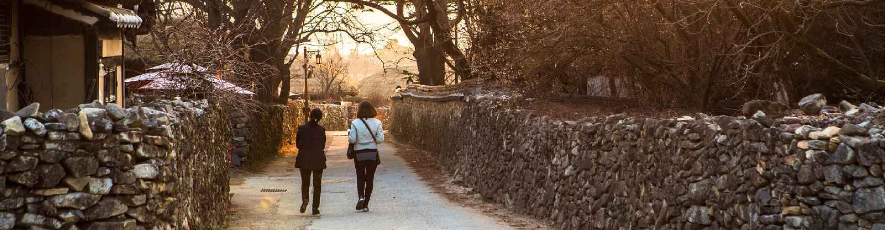 A rustic wooden bridge over a gentle stream leads you into a picture-perfect scene of old Korea, untouched by time.