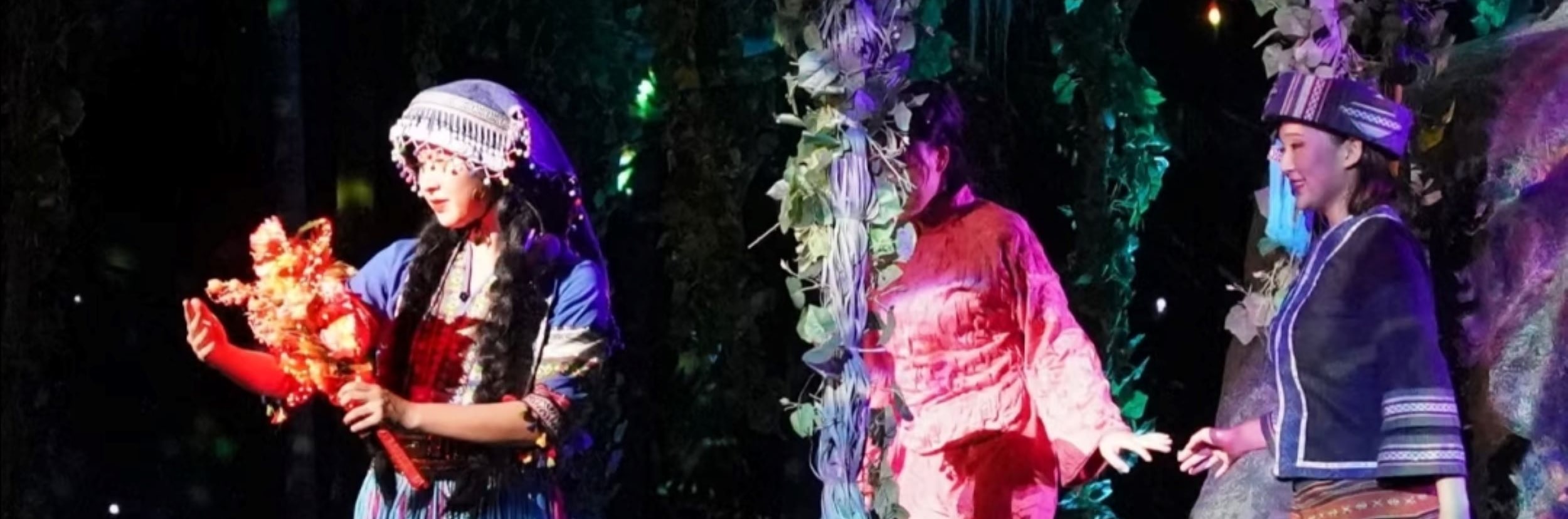 叢林佈景襯民族裝，演員持花互動，柔化戰場外的女性溫情