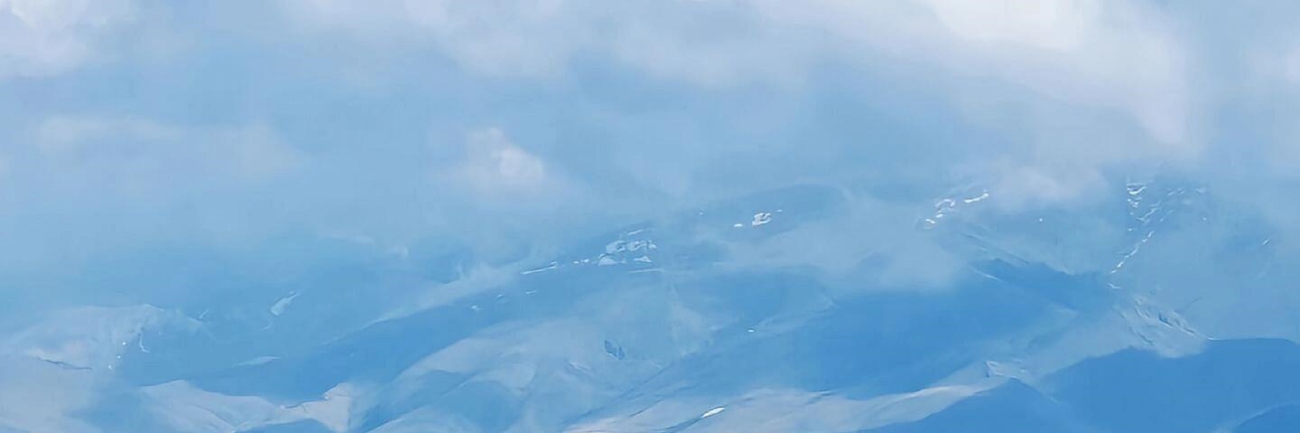 賽里木湖的藍湖與雪山相映成趣，淺灘小屋點綴其間