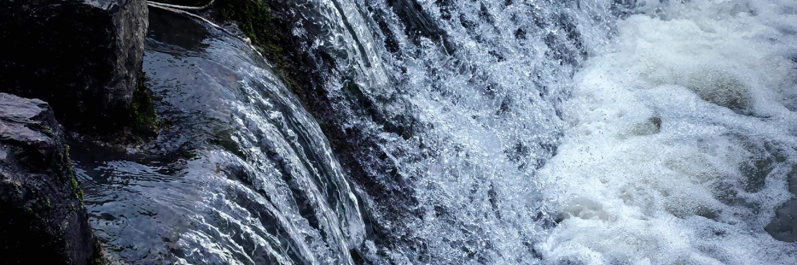 奔湧的水流順著層層石階傾瀉而下，撞出細碎的白色浪花，像無數條銀鏈在石縫間奔湧跳躍。深色的石階與清透的水流形成強烈的對比，把水的靈動與力量感展現得淋漓盡致，彷彿能聽見瀑布嘩嘩的聲響，撲面而來都是鮮活的自然氣息