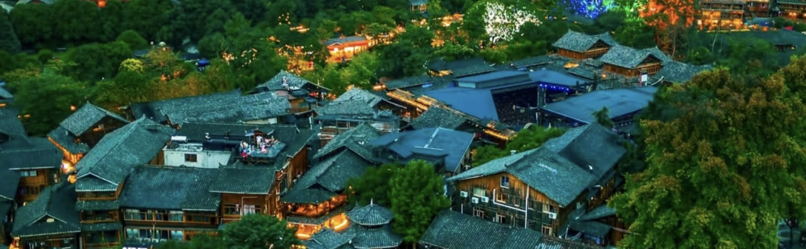 西江千戶苗寨：夜幕降臨，一定要登上觀景臺俯瞰【苗寨夜景】。青瓦楓木的苗家吊腳樓上，一盞盞燈火相繼點亮。或暖黃、或清亮的燈光從苗寨裡透出來，沿著30至70度的山坡鋪灑開，從遠處眺望，燈火闌珊、流光溢彩，山、樓、橋、水交相輝映。