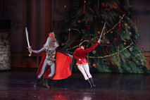The Mouse King in a grey costume and red cape duel