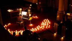 A piano surrounded by candles