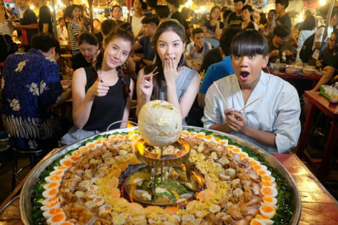 People with giant thai noodle dish