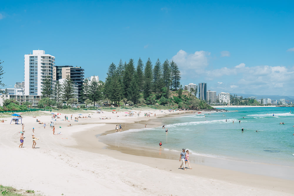 People swimming on Rainbow Bay and walking on its shore