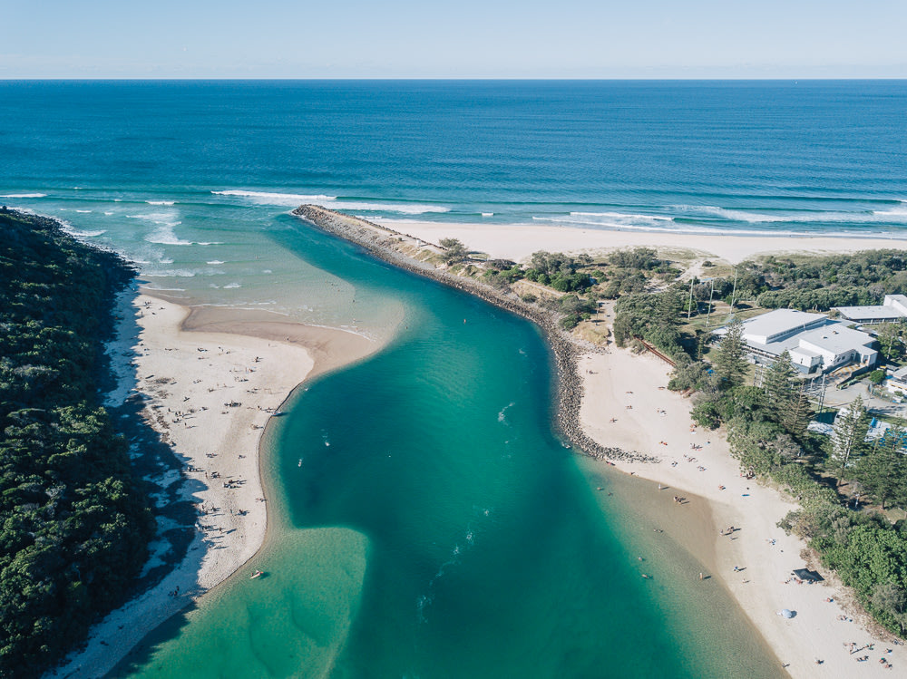 An aerial shot of the Tallebudgera Creek, showcasing its clear turquoise waters