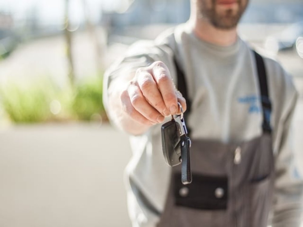 man holding car keys new zealand car rental phone 