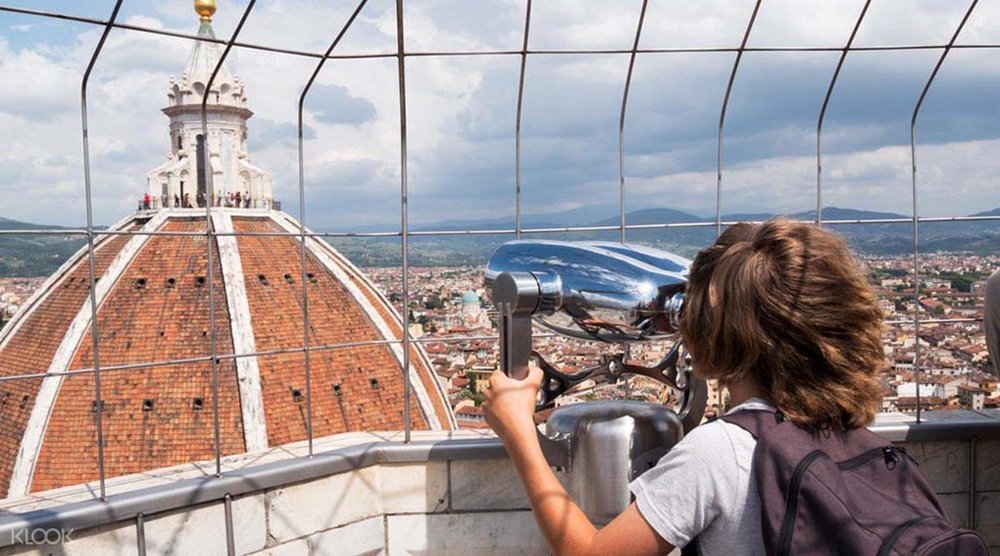 un turista mira la ciudad de florencia desde una de las terrazas de la catedral