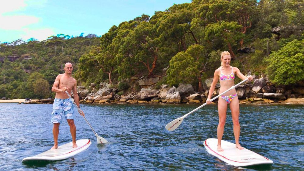  A merry group kayaking in the crystal clear waters of Manly