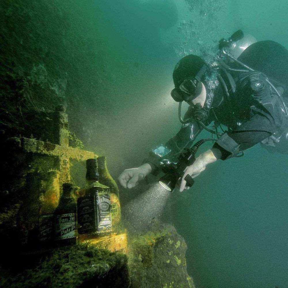 diver approaching alcohol bottle in diving spot in the philippines