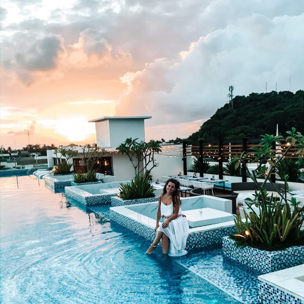woman dipping feet into a rooftop pool