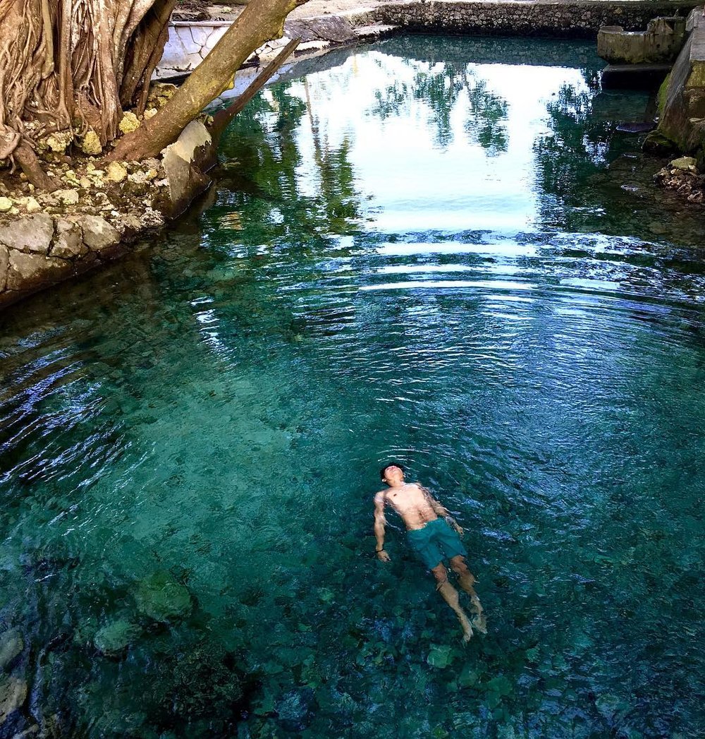 man floating on guiwanon cold spring lake in northern cebu