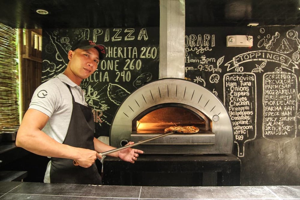 man near a woodfire grill in Kermit Siargao