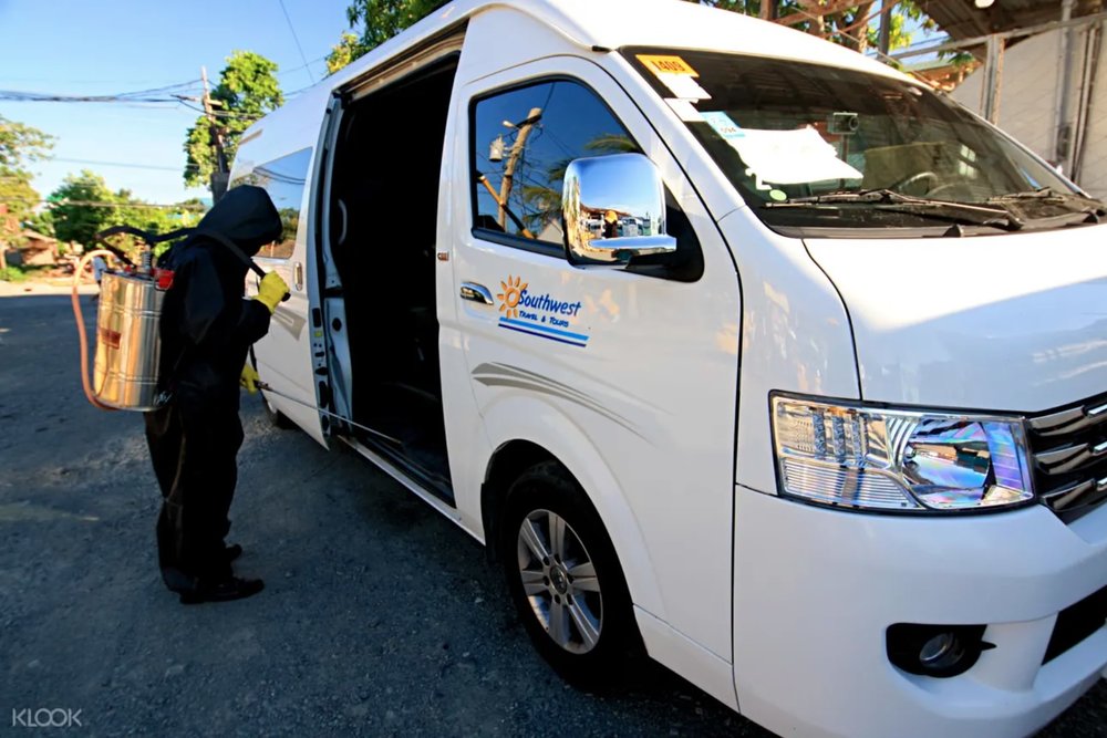 man in black ppe beside car on the way to boracay island