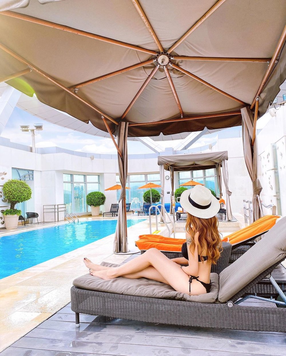 在香港康得思酒店游泳池池畔戴上草帽 瞬間讓人以為在外地旅行