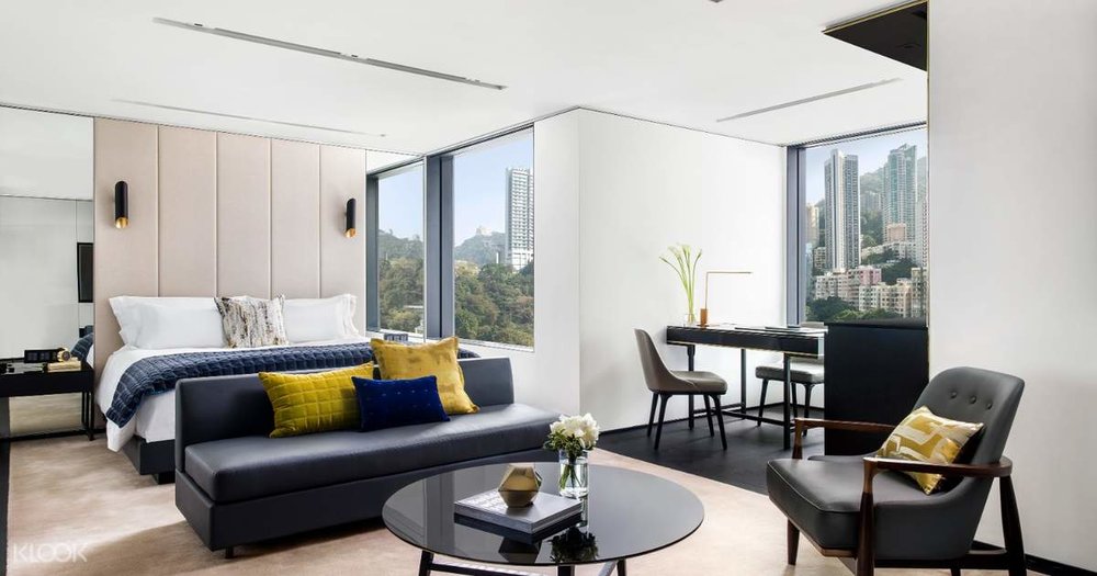 neutral bedroom with windows lounge area