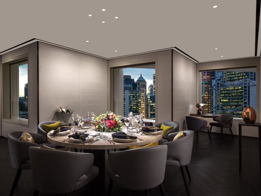 dining table in grey room with building view at murray hong kong