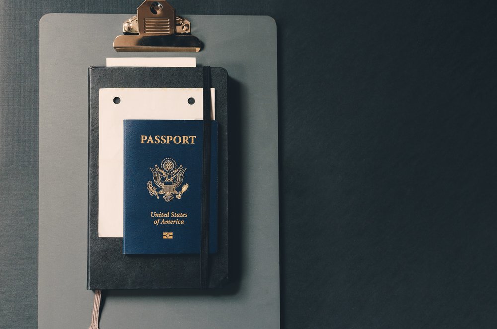 united states passport on top of a black notebook