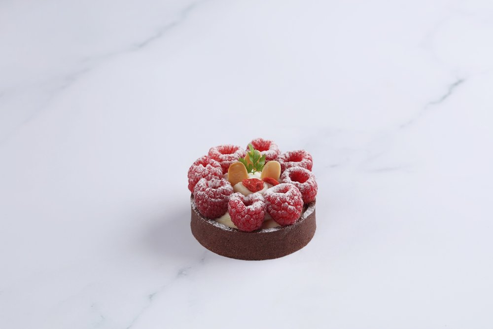 The Mira Hong Kong COCO 迷你Yuzu Praline Raspberry Tart，由柚子蛋黃醬、榛子軟心配新鮮紅桑子。