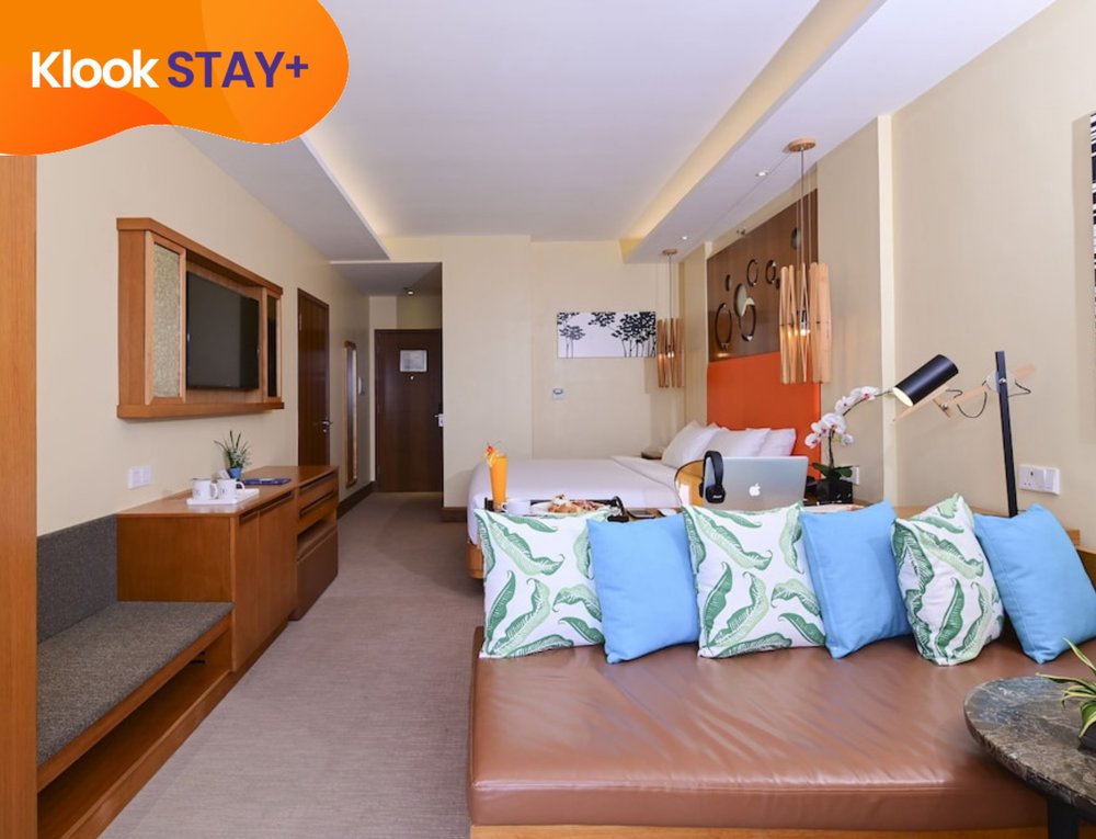 guestroom with apple laptop and lounge area at be resorts mactan