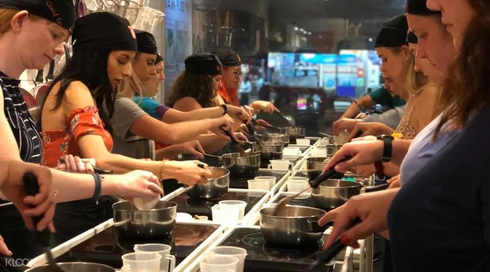 tourists learning how to cook thai dishes