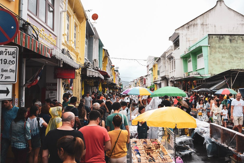 people wandering around a phuket marketplace