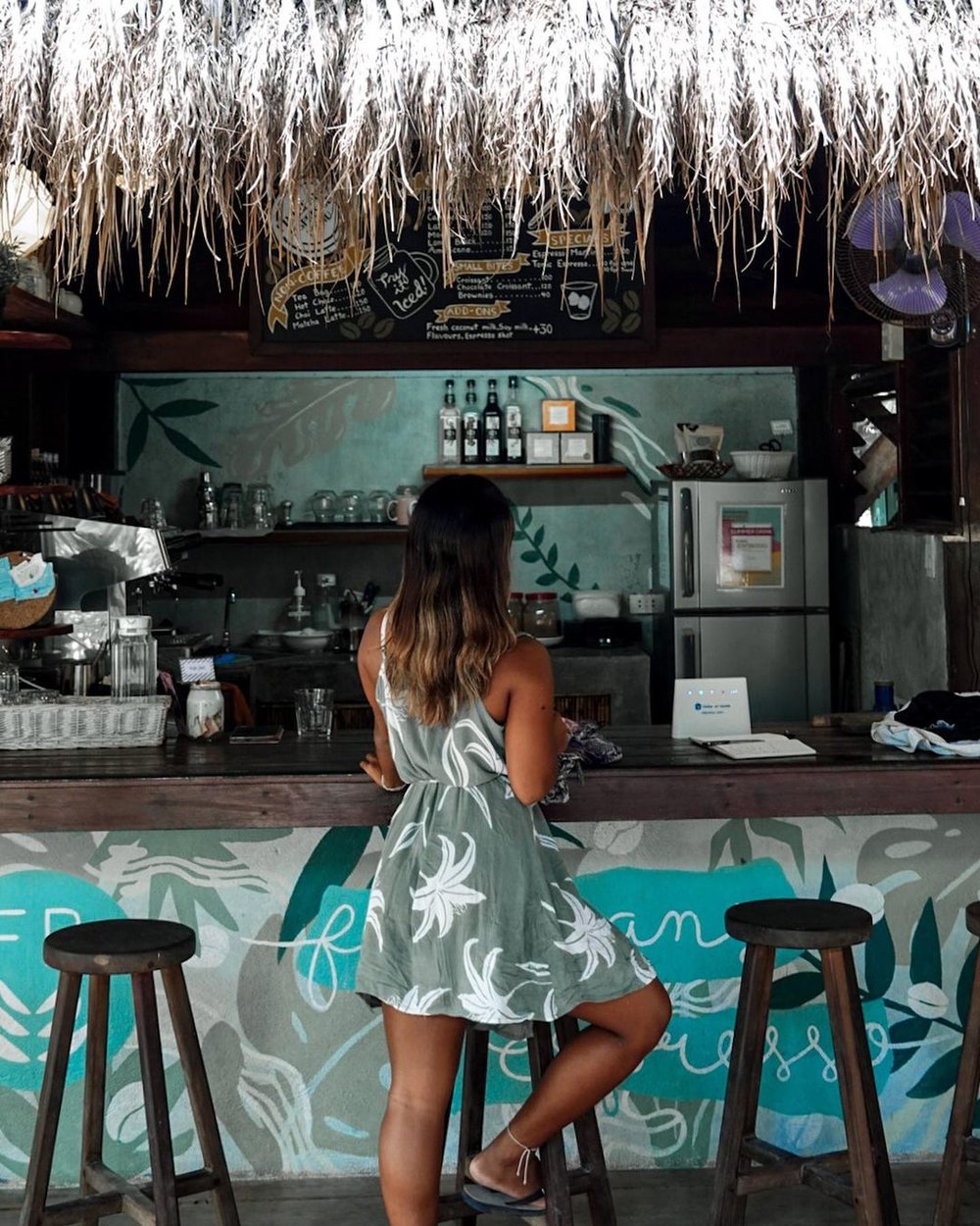girl in dress by coffee bar at filibeans harana surf cafe in siargao
