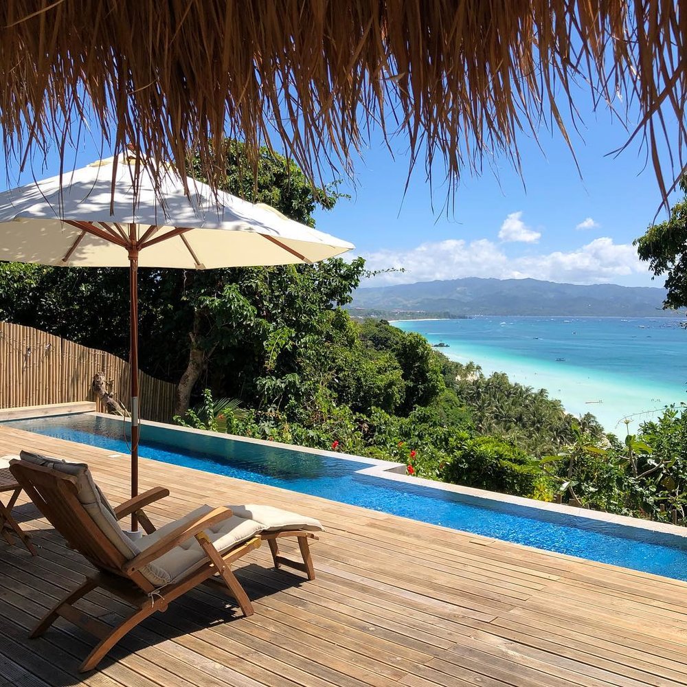 lounge chair at infinity pool deck overlooking beach at diniview villas boracay