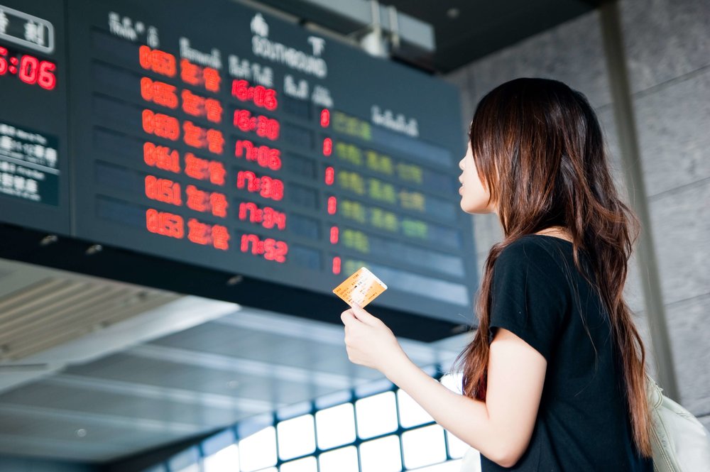 高鐵國旅聯票 高鐵取票方式 一個女人拿著高鐵車票