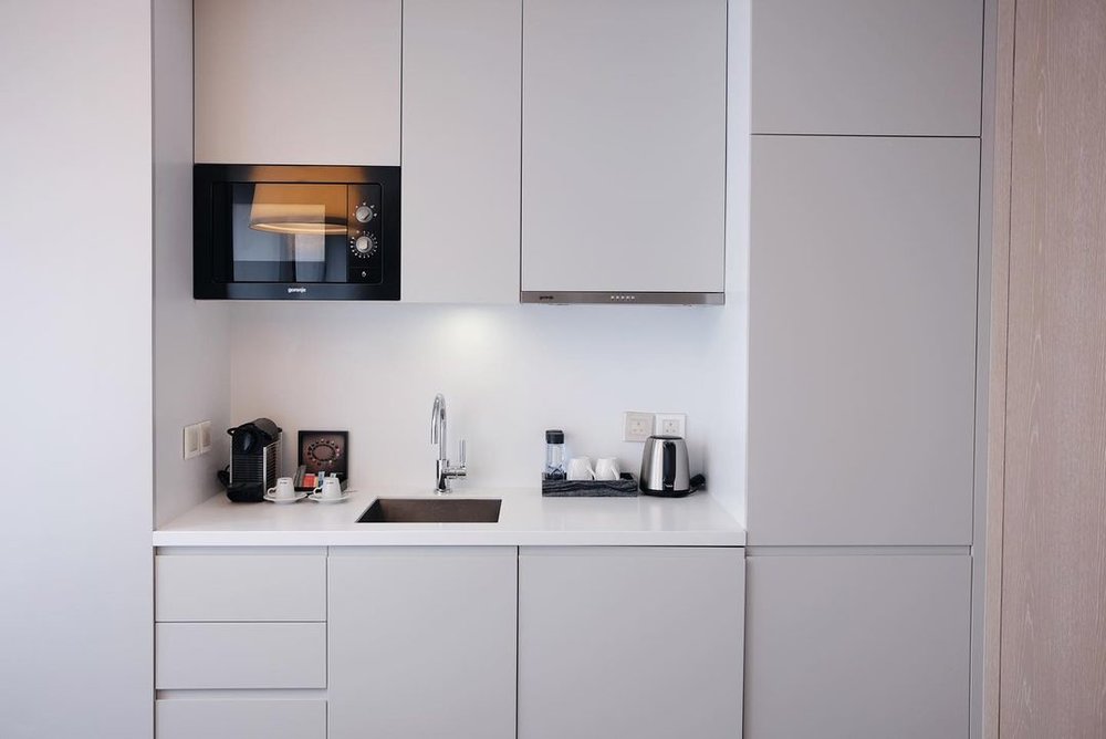 白色的開放式廚房，把雪櫃和用具都藏身起來，簡約素淨