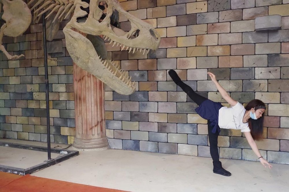 dancer beside dinosaur skeleton at museum at dinosaur island clark