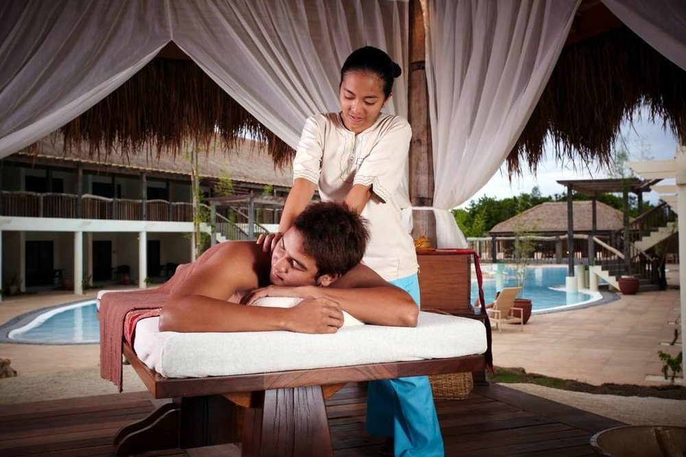 man being massaged by the pool at bluewate panglao
