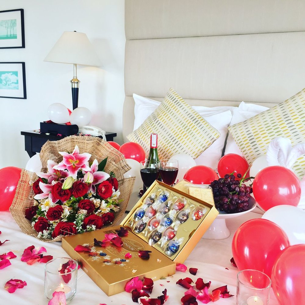 bed with chocolates and flowers