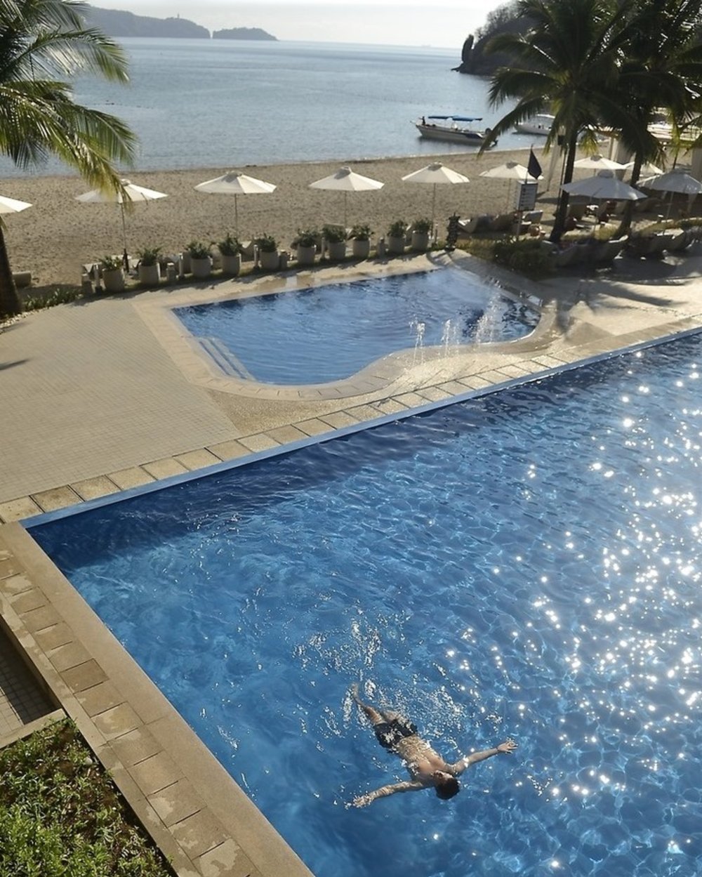 boy swimming in infinity pool