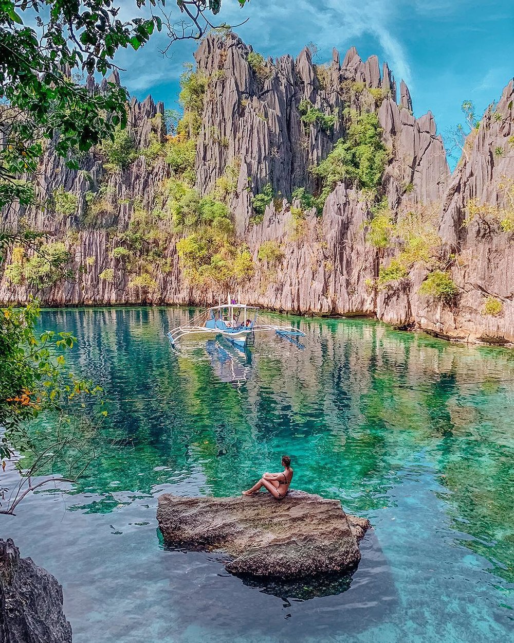 girl in the middle of rock in blue lake