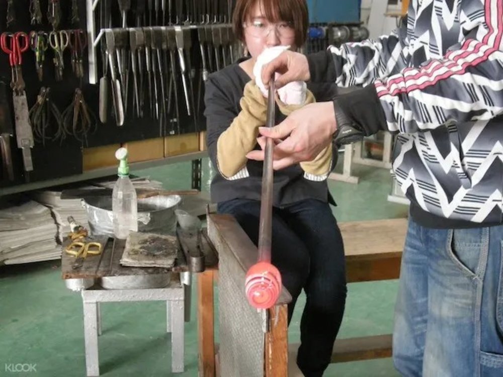 21492 吹きガラス作り体験 ガラスを膨らませる女性