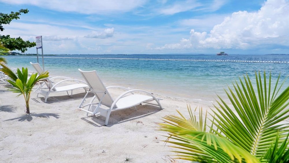 white lounge chairs in front of beach