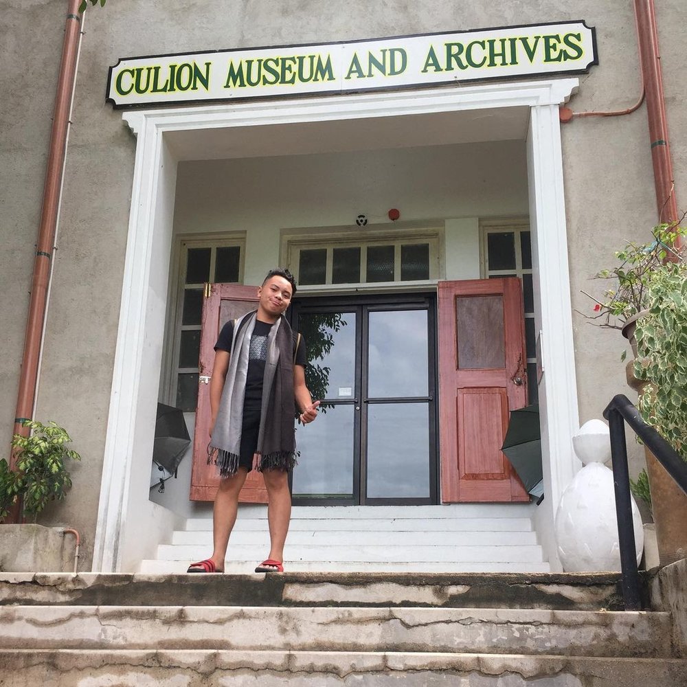 man thumbs up in front of museum