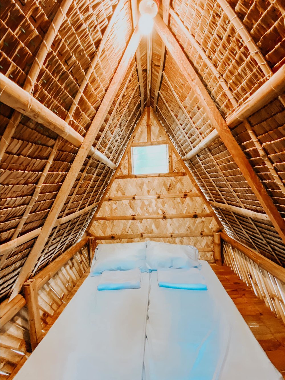 inside a frame nipa hut with two solo beds