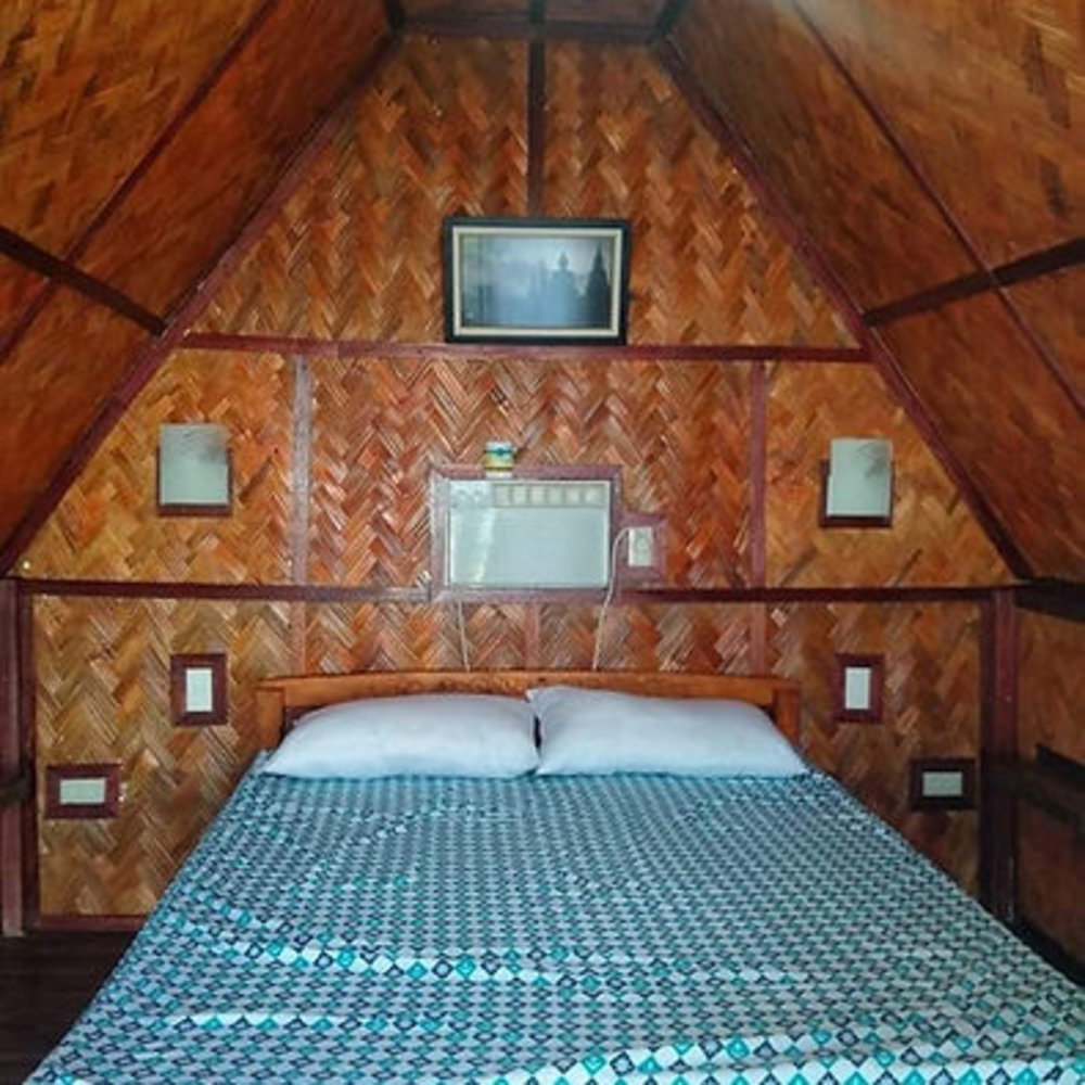 queen bed inside nipa hut