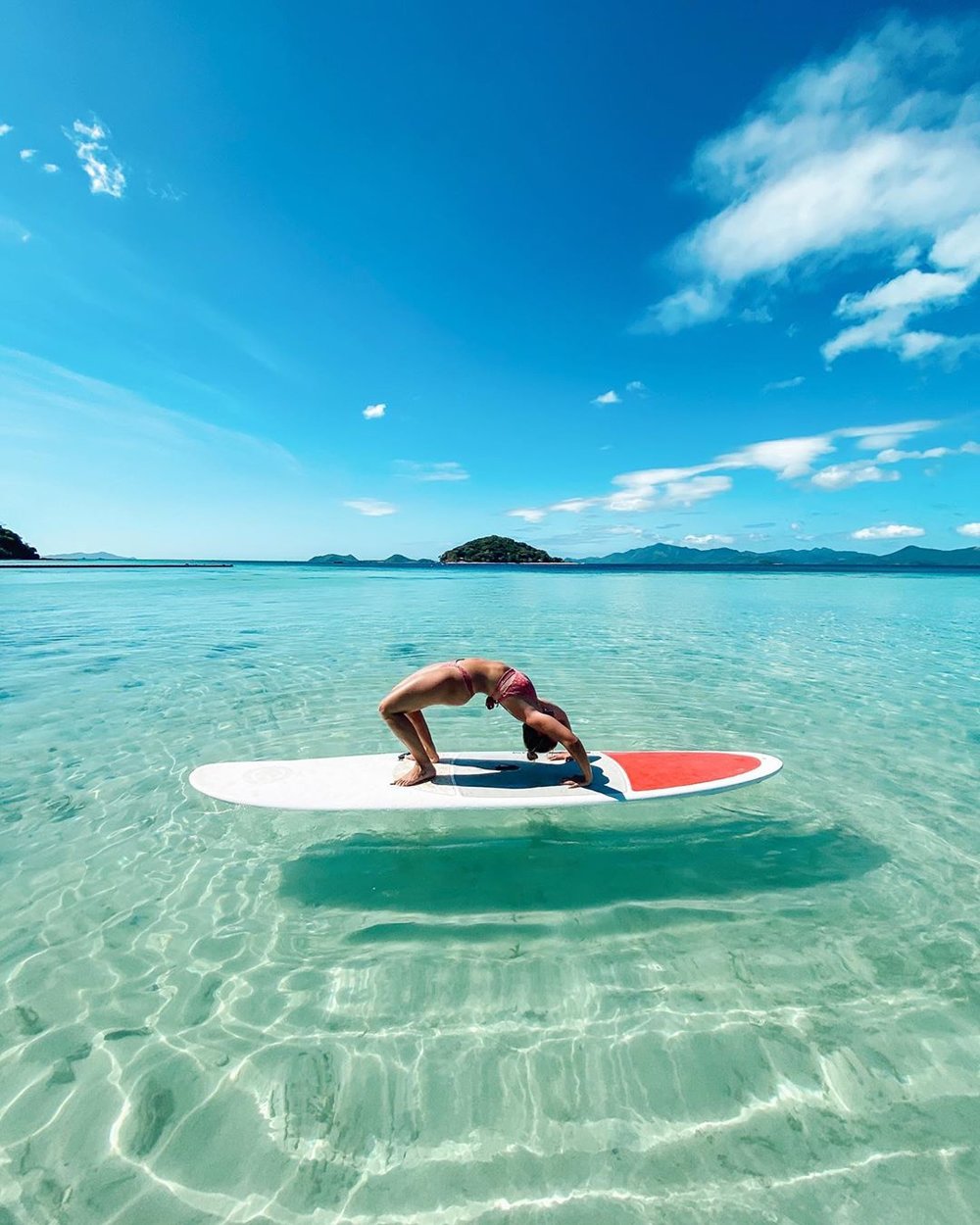 woman balancing on top of surfboard in ocean