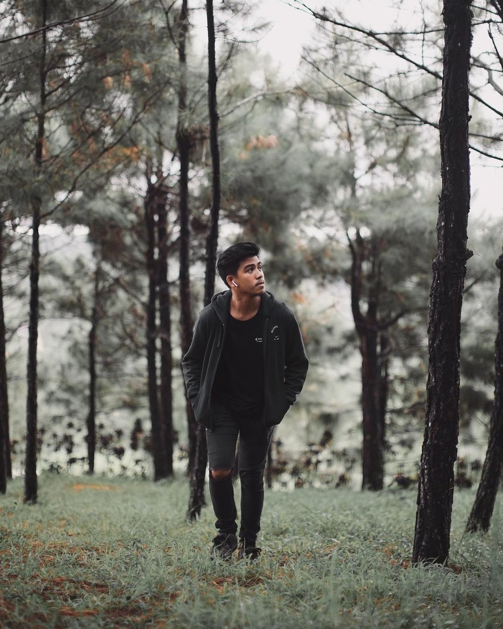 man standing in the middle of forest