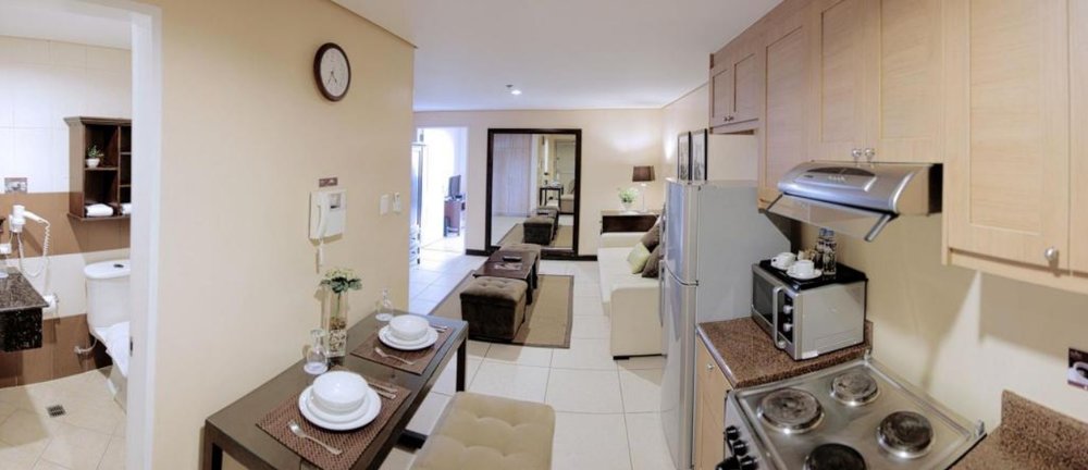 spacious hotel room with kitchen and living area